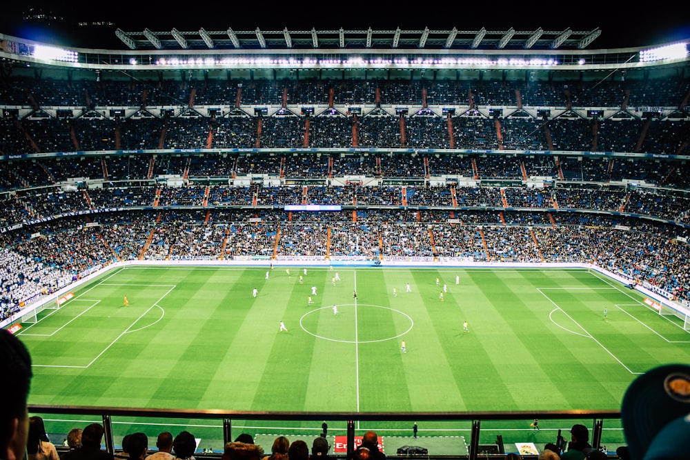 Lapangan sepak bola kosong dengan lampu menyala di malam hari