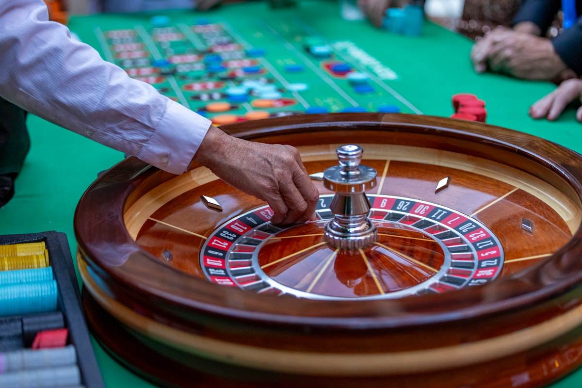 Pemain mengikuti permainan roulette di meja hijau