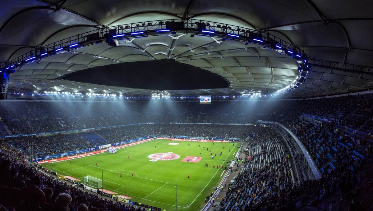 Stadion sepak bola dengan lampu sorot menyala sebelum pertandingan